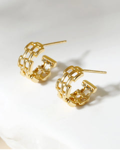 Chunky gold huggie earrings worn on ear bold minimalist style