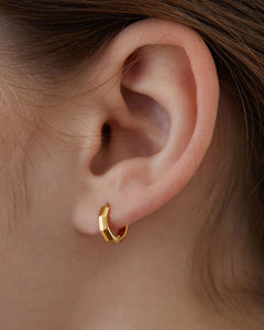 10mm mini gold huggie earrings worn on ear minimalist everyday gold jewelry