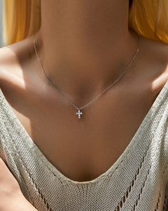 Model wearing dainty moissanite cross necklace