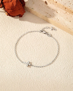 Flat lay of 925 sterling silver cross moissanite bracelet