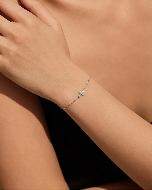 Dainty cross bracelet with sparkling moissanite stones on model