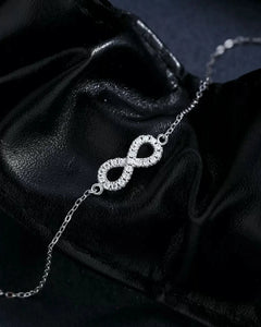 Infinity moissanite bracelet on black leather background