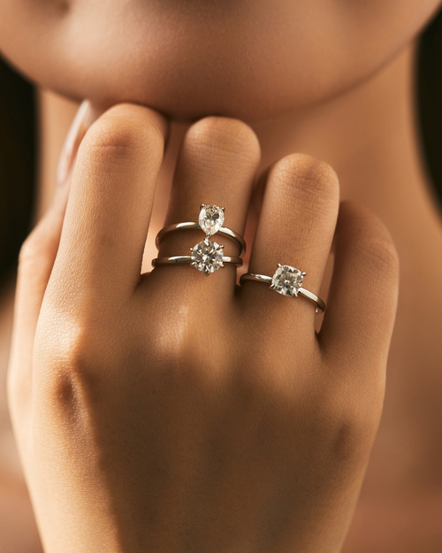 Three Solitaire Moissanite Rings – Round, Pear, and Cushion Cut
