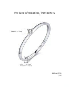 Close-up of dainty moissanite solitaire ring