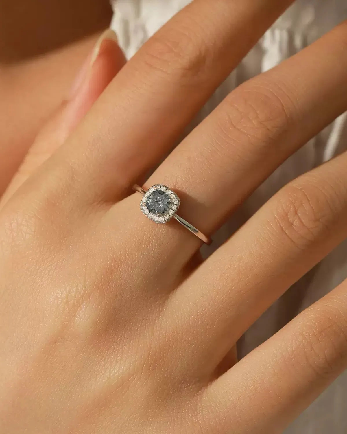 Gray moissanite cushion halo ring worn on hand