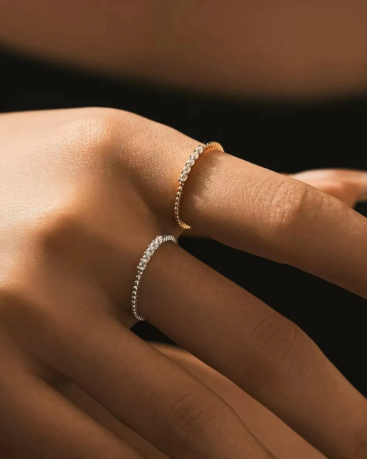 Moissanite stacking rings worn on hand for size reference