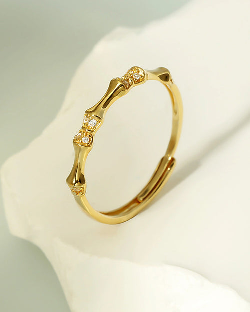 Bamboo inspired adjustable gold ring top view on marble background