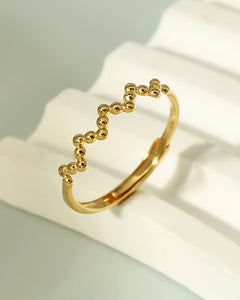 Modern beaded gold adjustable ring on marble background