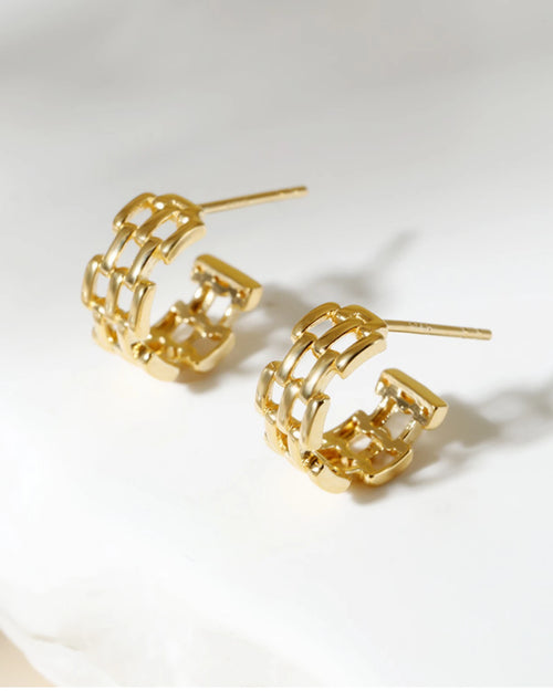 Chunky gold huggie earrings worn on ear bold minimalist style
