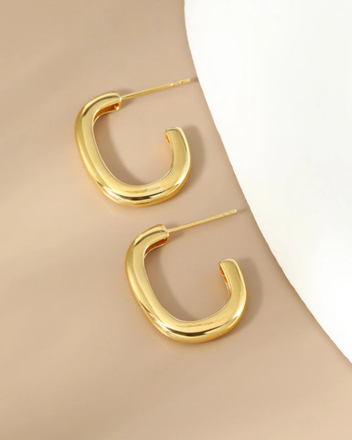 Minimalist gold hoop earrings flat lay polished 18K gold plated finish
