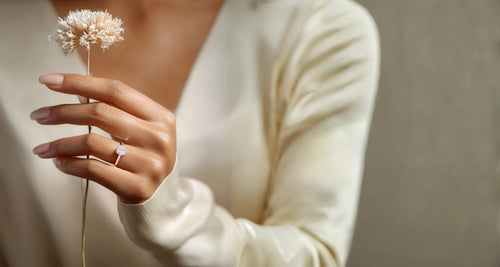 Woman holding a dried flower wearing a rose-gold halo solitaire ring – AriaEcho Jewelry
