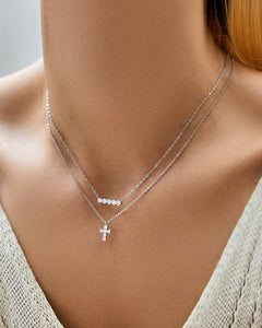 Layered styling with silver moissanite cross necklace