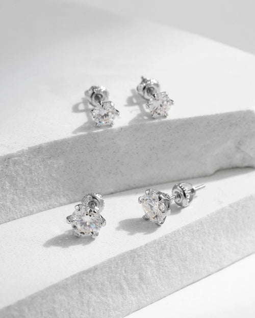 Classic round moissanite stud earrings on white stone background