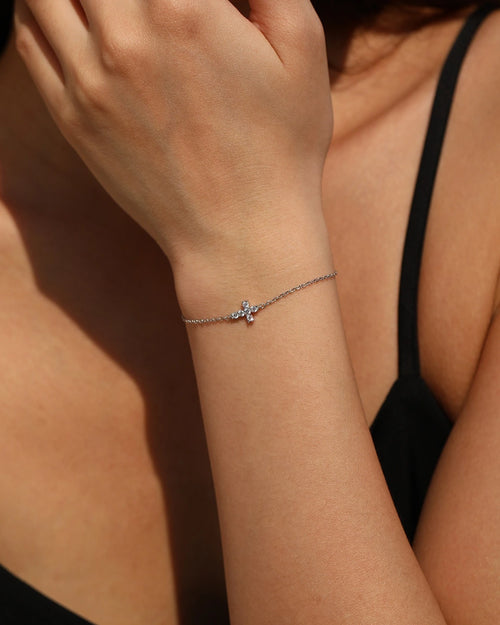Delicate sterling silver cross bracelet with moissanite on wrist