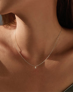 Delicate round moissanite pendant necklace on model