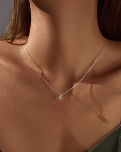 Delicate round moissanite pendant necklace on model