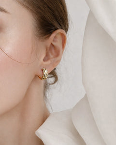 Minimalist gold huggie hoop earrings worn on ear
