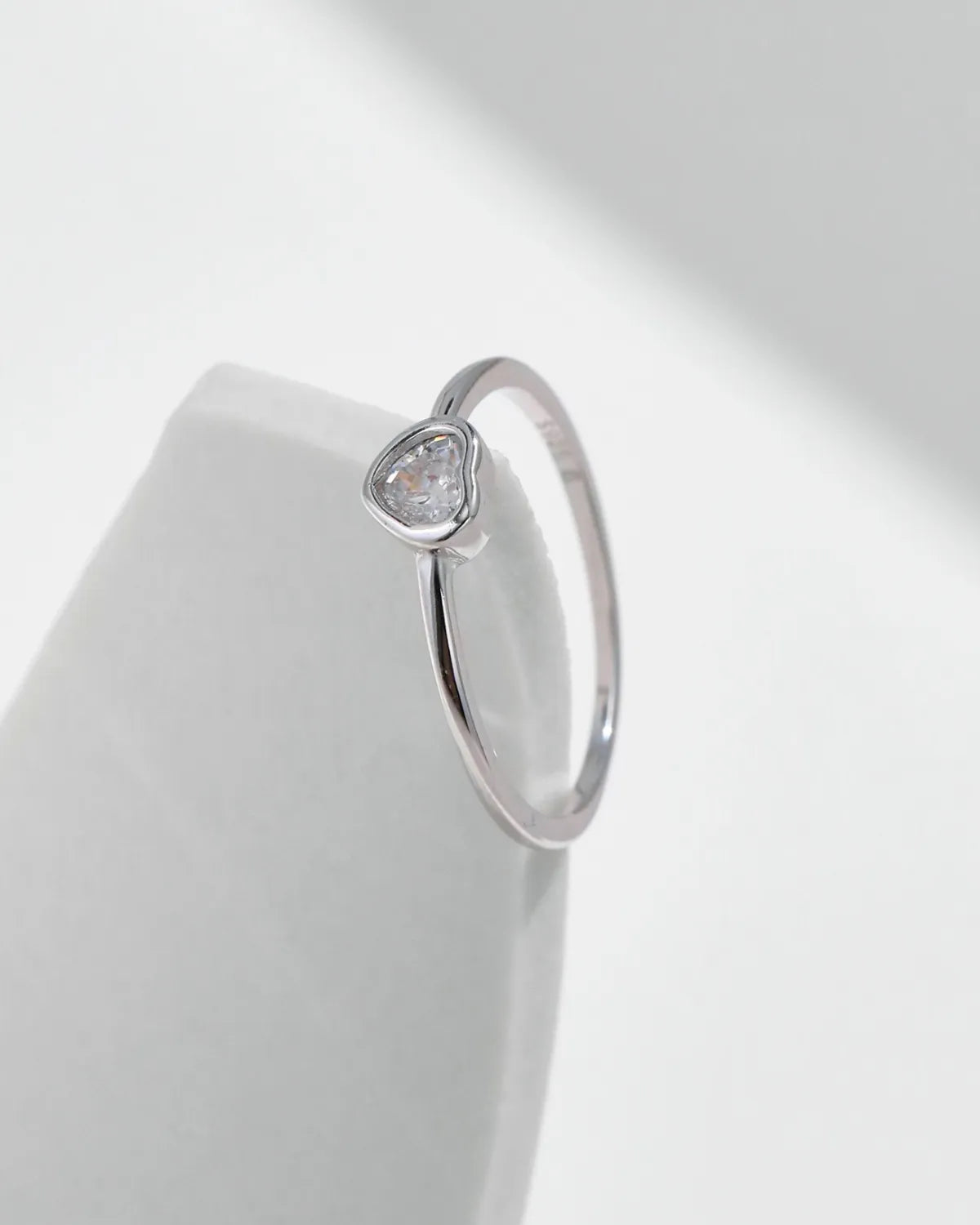 heart shape moissanite ring close-up on white surface