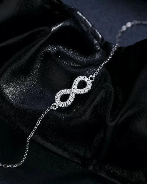 Infinity moissanite bracelet on black leather background