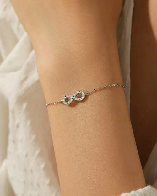 Model wearing dainty infinity moissanite bracelet on wrist